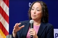 Catherine Lhamon holds a microphone while speaking in front of a blue Center for American Progress background.