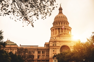 The Texas statehouse, topped with its prominent dome, at sunset.