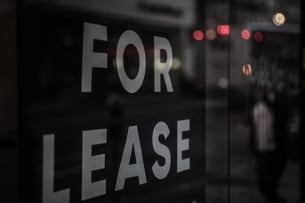 A photo of a "for lease" sign in a window