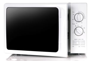 A white microwave with two large knobs.