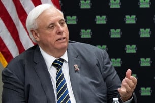 A photo of West Virginia governor Jim Justice, a light-skinned man with white hair, speaking
