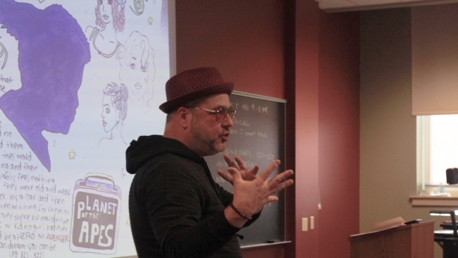 A Millersville University professor speaks to students, gesturing with his hands.