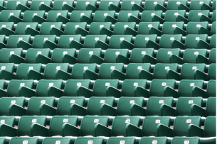 Rows of green stadium bleacher seats, suggesting "cheap" or "nosebleed" seats.